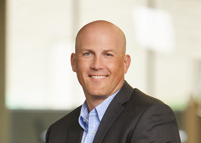 Darrin in a blue shirt and suit jacket smiling for the camera