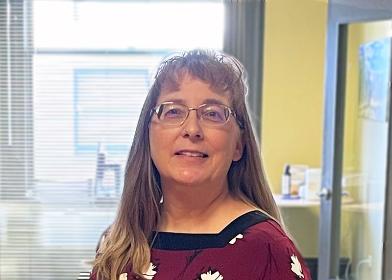 Deanna in a read blouse in an office setting